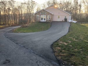 newly paved driveway up a hill to the back of a house, paving services